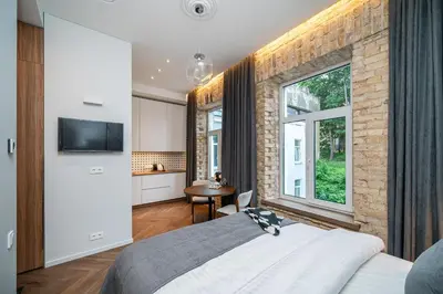 a bedroom with a large bed and a brick wall at Art Boutique I Old Town Apartments w-AC I cohost in Vilnius