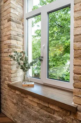 a window with a vase of flowers on a wooden window sill at Art Boutique I Old Town Apartments w-AC I cohost in Vilnius
