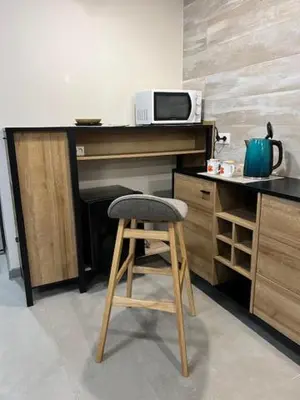 a wooden stool in a kitchen with a microwave at Gabriel in Šveicarija