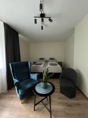 a bedroom with a bed and a chair and a table at Jaukaus buto nuoma Šiaulių rajone in Šapnagiai