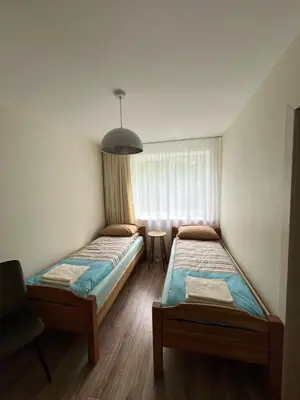 two beds in a room with a window at Jaukaus buto nuoma Šiaulių rajone in Šapnagiai