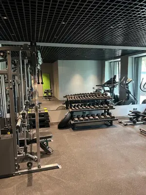 a gym with a lot of treadmills and machines at Nemunas Park Apartment in Prienai