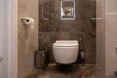 a bathroom with a toilet and a trash can at VIXI Skylum in Vilnius