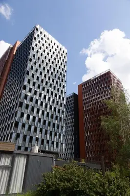 two tall buildings with trees in front of them at VIXI Skylum in Vilnius