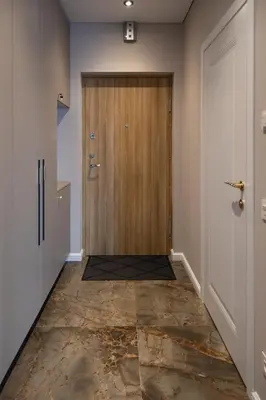 a hallway with a wooden door and a tile floor at VIXI Skylum in Vilnius