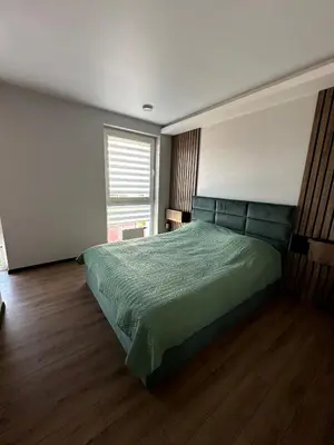a bedroom with a green bed and a window at Budiniškiu apartamentai in Vilnius