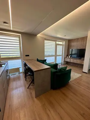 a living room with a table and a couch at Budiniškiu apartamentai in Vilnius