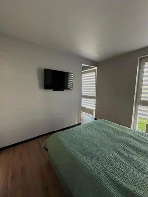 a bedroom with a bed and a flat screen tv at Budiniškiu apartamentai in Vilnius