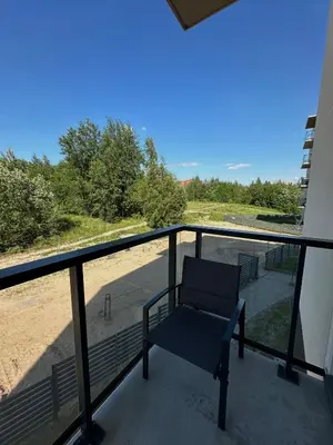 a blue chair sitting on a balcony with a view at Budiniškiu apartamentai in Vilnius