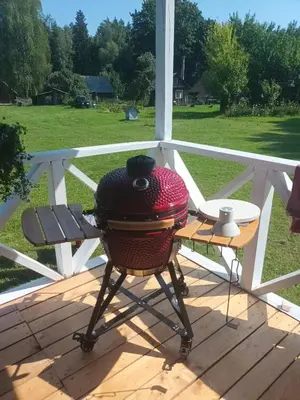 a bbq grill on a porch with a table at Malinada-kaimo sodyba in Šalčininkai
