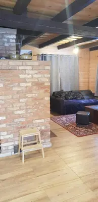 a room with a brick wall and a bed and a stool at Malinada-kaimo sodyba in Šalčininkai