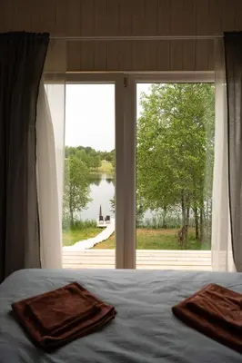 a bedroom with a bed and a large window at Pineplace trio KOPA in Žaugėdai