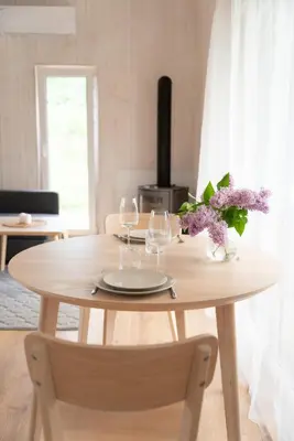 a table with two wine glasses and purple flowers on it at Pineplace trio KOPA in Žaugėdai