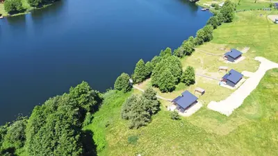 an aerial view of a farm with a lake at Pineplace trio KOPA in Žaugėdai