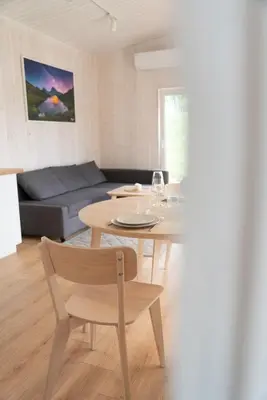 a living room with a table and a couch at Pineplace trio KOPA in Žaugėdai
