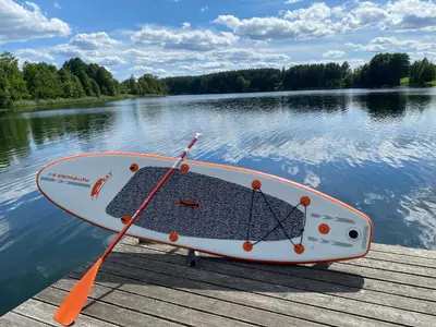 a boat sitting on a dock on a lake at Pineplace trio JŪRA in Žaugėdai