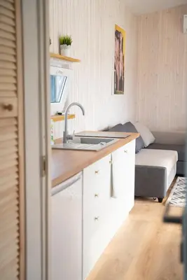 a kitchen with a sink and a bed in a room at Pineplace trio JŪRA in Žaugėdai