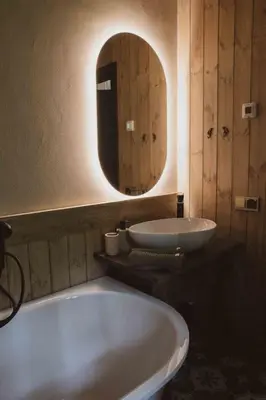a bathroom with a tub and a sink and a mirror at Kupetaite - Straw Bale Cabin in Nature in Družai