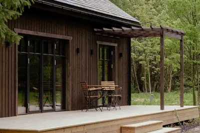 a cabin with a table and chairs on a deck at Kupetaite - Straw Bale Cabin in Nature in Družai