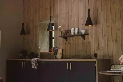 a kitchen with a counter with a sink and a mirror at Kupetaite - Straw Bale Cabin in Nature in Družai