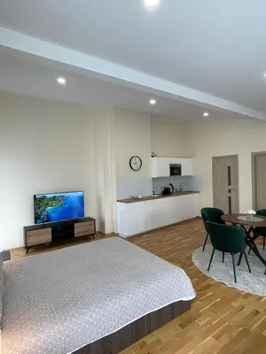a bedroom with a bed and a table and a tv at Vilijos apartamentai in Kaunas