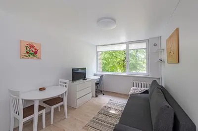 a living room with a couch and a table and a desk at Partizanų studio apartment #3 by Polo Apartments in Kaunas