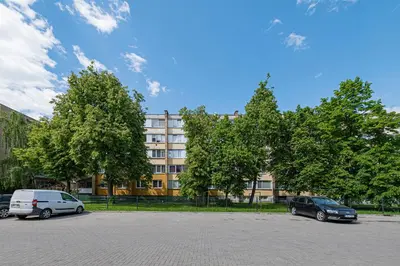two cars parked in a parking lot in front of a building at Partizanų studio apartment #3 by Polo Apartments in Kaunas