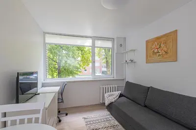 a living room with a couch and a desk and a window at Partizanų studio apartment #3 by Polo Apartments in Kaunas
