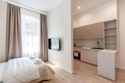 a bedroom with a bed and a kitchen at StudioApart23 in Vilnius