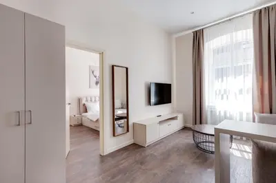 a white room with a mirror and a bed at StudioApart23 in Vilnius
