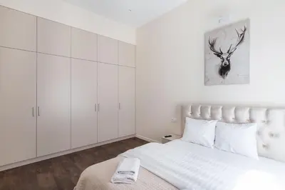 a white bedroom with a bed and white cabinets at StudioApart23 in Vilnius