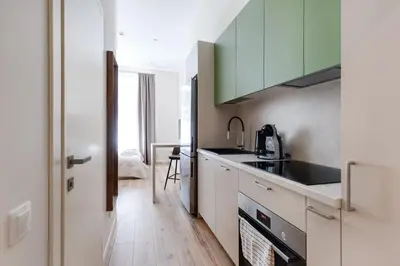 a kitchen with white cabinets and a sink at StudioApart23 in Vilnius