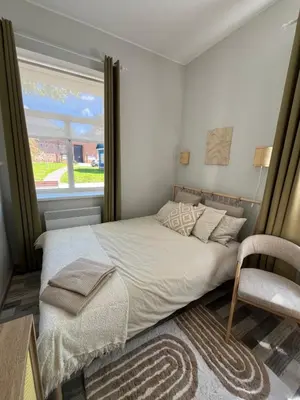 a bedroom with a bed and a chair and a window at Cozy BOHO room in Trakai Old town in Trakai