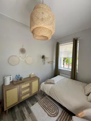 a bedroom with a bed and a window and a chandelier at Cozy BOHO room in Trakai Old town in Trakai