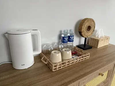 a counter with a coffee maker and bottles of water at Cozy BOHO room in Trakai Old town in Trakai
