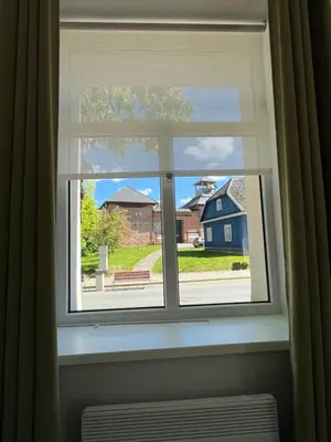 a window with a view of a blue house at Cozy BOHO room in Trakai Old town in Trakai