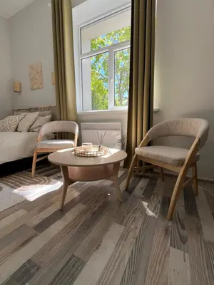 a living room with a coffee table and two chairs at Cozy BOHO room in Trakai Old town in Trakai