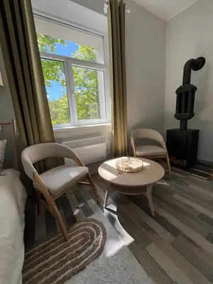 a living room with two chairs and a table and a stove at Cozy BOHO room in Trakai Old town in Trakai