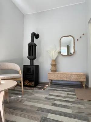 a living room with a wood stove and a mirror at Cozy BOHO room in Trakai Old town in Trakai