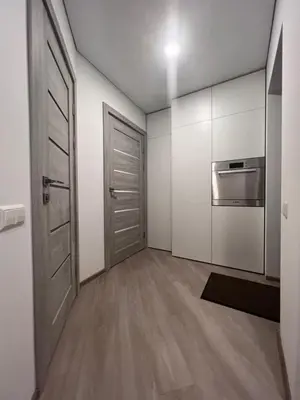an empty room with a door and a kitchen at Kepezinski SPA apartments in Kaunas