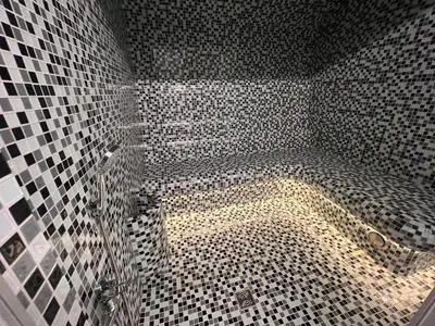 a bathroom with a shower with black and white tiles at Kepezinski SPA apartments in Kaunas