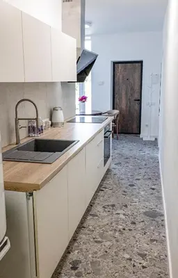 a kitchen with white cabinets and a counter top at PLENTO g APARTAMENTAI BIRŽUOSE in Biržai
