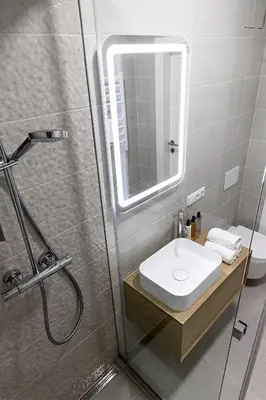a bathroom with a sink and a shower at PLENTO g APARTAMENTAI BIRŽUOSE in Biržai