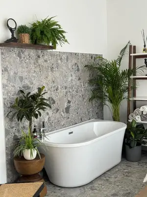 a white bath tub in a bathroom with plants at PLENTO g APARTAMENTAI BIRŽUOSE in Biržai