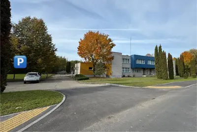 a car parked on a road in front of a building at PLENTO g APARTAMENTAI BIRŽUOSE in Biržai