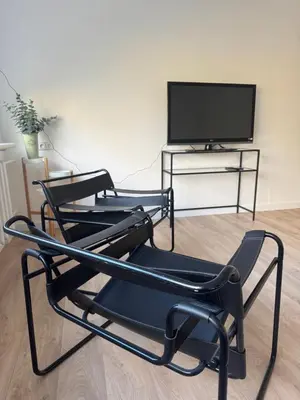 two black chairs sitting in front of a tv at PLENTO g APARTAMENTAI BIRŽUOSE in Biržai