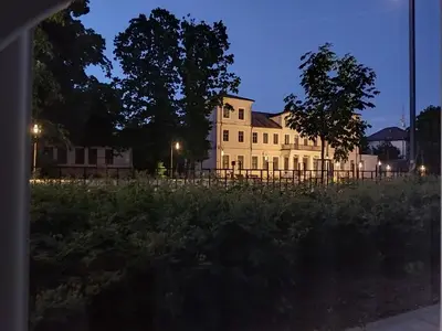 a white house with a fence in front of it at Aušros Alėjos Apartamentai in Šiauliai