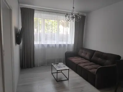 a living room with a couch and a table at Aušros Alėjos Apartamentai in Šiauliai
