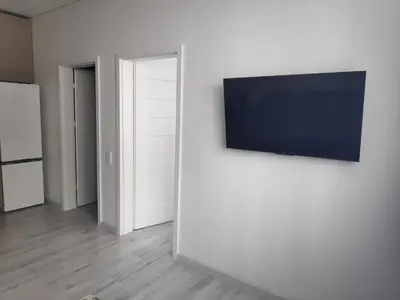 a living room with a flat screen tv on a wall at Aušros Alėjos Apartamentai in Šiauliai