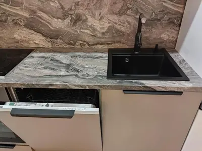 a kitchen counter with a sink and a stove at Aušros Alėjos Apartamentai in Šiauliai